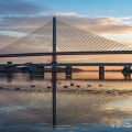 Sunrise behind the main span of the Veteran's Glass City Skyway, also known as the Toledo Skyway Bridge, which carries Interstate I-280 for more than one and a half miles over the Maumee River and surrounding lowlands near Toledo. The bridge, which opened in 2007 and cost around $237 million, is the largest construction project ever carried out by the Ohio Department of Transportation.
